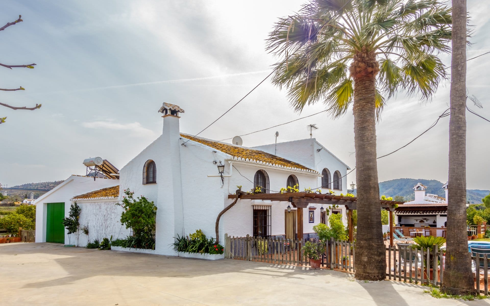 Secure parking area within the property surrounded by fruit trees.